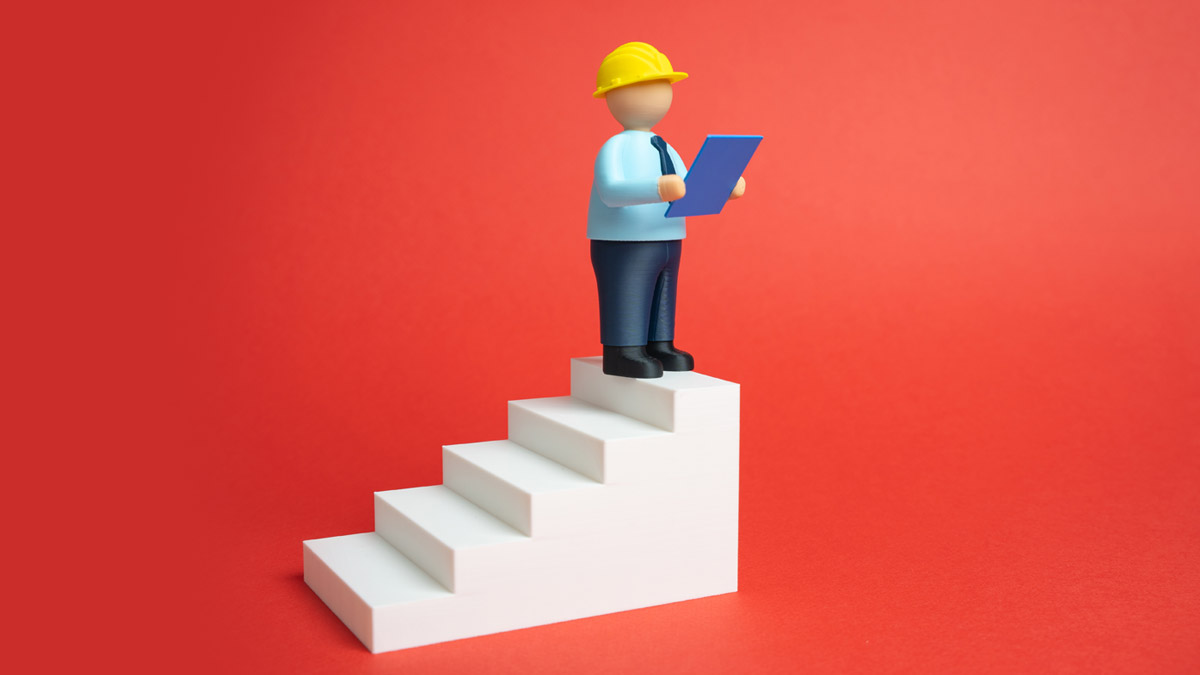 A small figure wearing a yellow hard hat and a blue shirt stands on the top step of white stairs, holding a blue clipboard against a red background.
