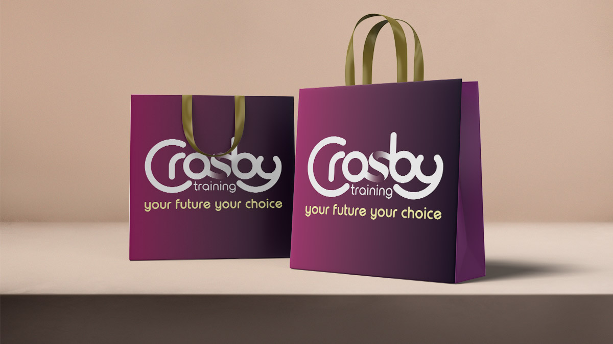 Two stylish burgundy get bags with Crosby Training logos and gold handles.