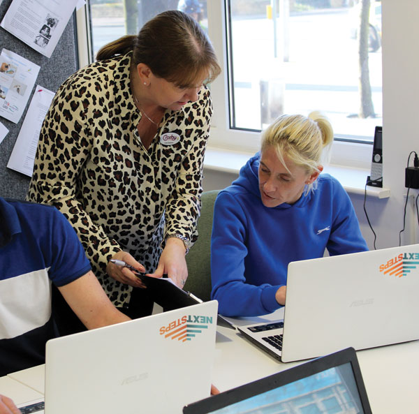 Lisa having a conversation with a female learner with a laptop open in front of her.