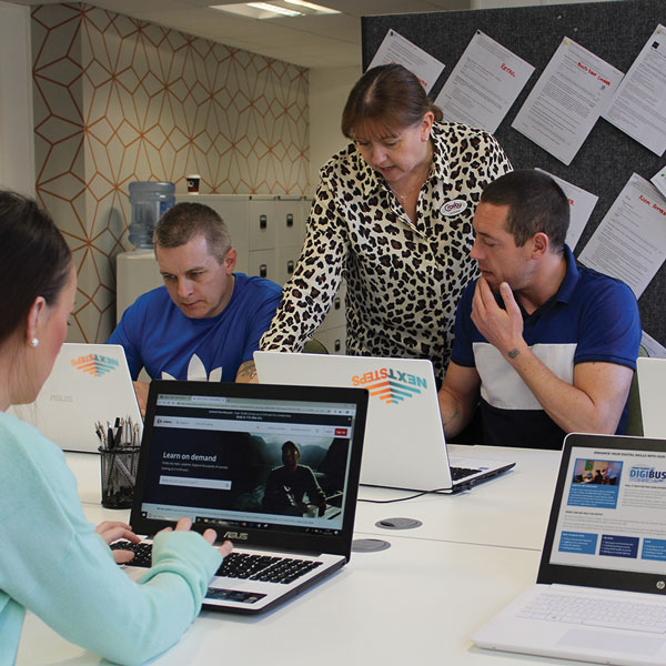 Tutor Lisa Sumner, in our Next Steps Centre, pointing to a laptop a learner is using. She appears to be explaining something.