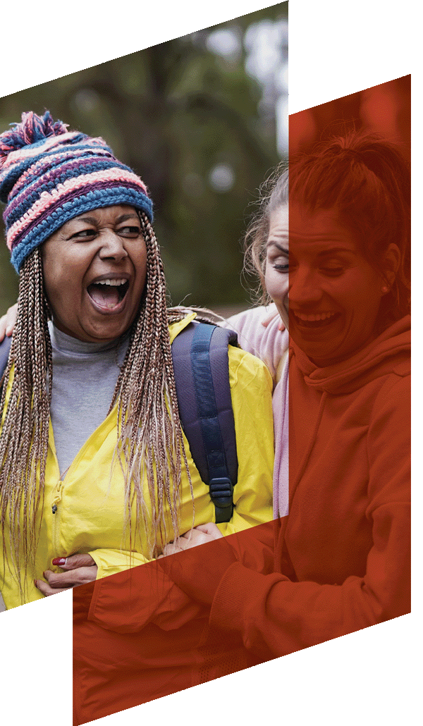 Two women on an outdoor activity, one in a wooly hat.
